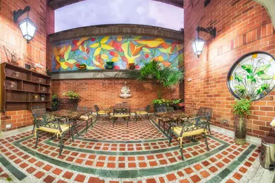 a room with a brick wall with a colorful mural at Hotel San Pedro del Fuerte in Medellín