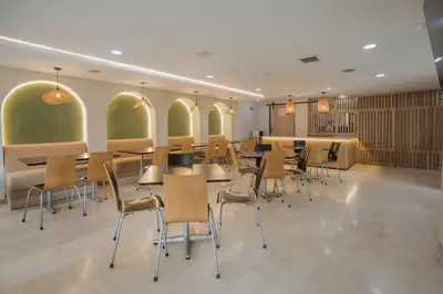 a restaurant with tables and chairs in a room at Hotel Portón Sabaneta in Sabaneta