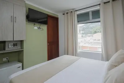 a bedroom with a bed and a large window at Hotel Portón Sabaneta in Sabaneta