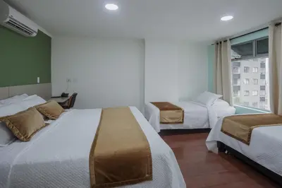 a hotel room with two beds and a window at Hotel Portón Sabaneta in Sabaneta