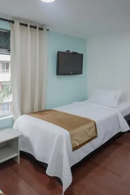 a bedroom with a bed and a tv on the wall at Hotel Portón Sabaneta in Sabaneta