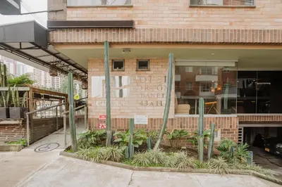 a brick building with plants in front of it at Hotel Portón Sabaneta in Sabaneta