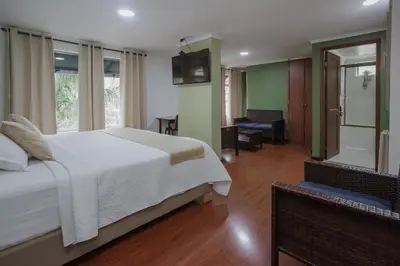 a bedroom with a bed and a room with a desk at Hotel Portón Sabaneta in Sabaneta