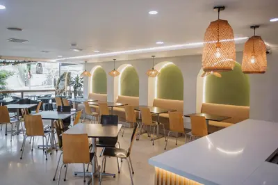 a restaurant with tables and chairs and windows at Hotel Portón Sabaneta in Sabaneta