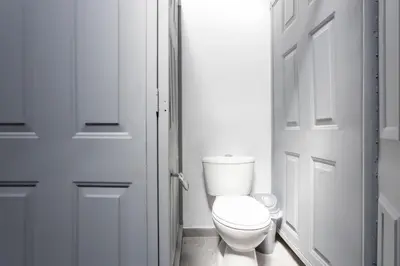 a white bathroom with a toilet and a door at Gastón Coliving in Medellín