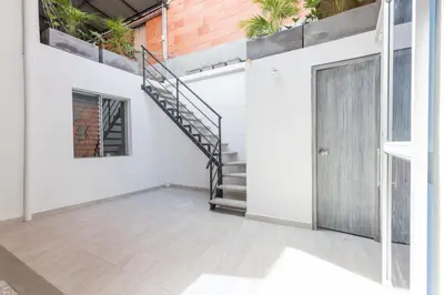a staircase in a white building with a door at Gastón Coliving in Medellín
