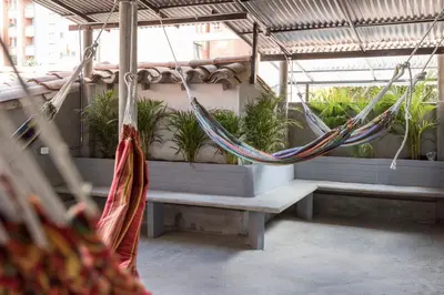 a patio with hammocks and potted plants on benches at Gastón Coliving in Medellín