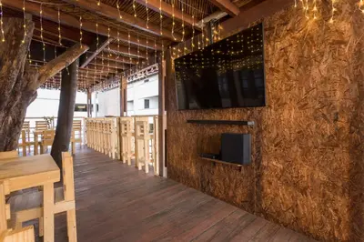 a dining room with a tv on a wall at Parceros Med Hostel in Medellín