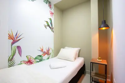 a bedroom with a bed with a flower mural on the wall at Parceros Med Hostel in Medellín