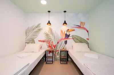 two beds in a room with a mural on the wall at Parceros Med Hostel in Medellín