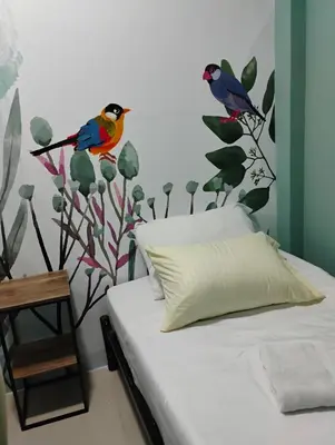 a bedroom with a bed with birds on the wall at Parceros Med Hostel in Medellín