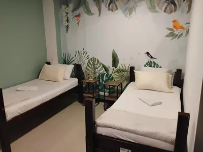 two beds in a room with plants on the wall at Parceros Med Hostel in Medellín