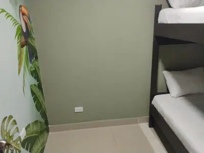 a room with two bunk beds and a green wall at Parceros Med Hostel in Medellín