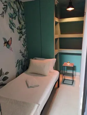a small room with a bed and a side table at Parceros Med Hostel in Medellín