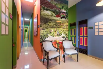 a hallway with two chairs and a table with a painting on the wall at Parceros Med Hostel in Medellín