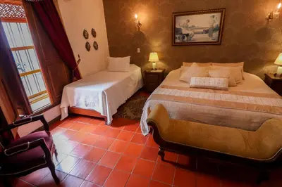 a bedroom with two beds and a chair at Casa Lola Hotel Boutique in Salamina