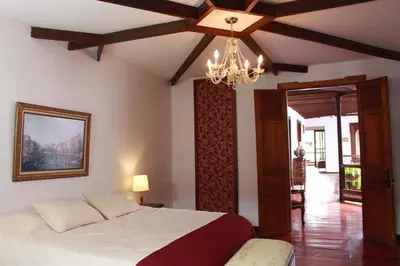 a bedroom with a large bed and a chandelier at Casa Lola Hotel Boutique in Salamina