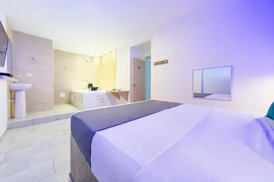 a bedroom with a large bed and a bathroom at Ayenda Panamericana in Manizales