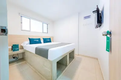 a bedroom with a bed with blue pillows on it at Ayenda Panamericana in Manizales