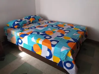 a bed with a colorful comforter in a room at Big House Medellin in Medellín
