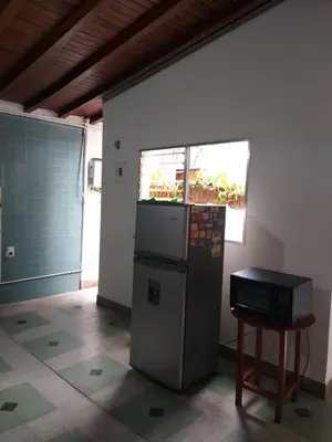 a refrigerator in the corner of a room with a table at Big House Medellin in Medellín
