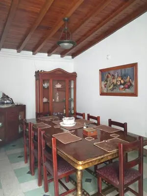 a dining room with a wooden table and chairs at Big House Medellin in Medellín