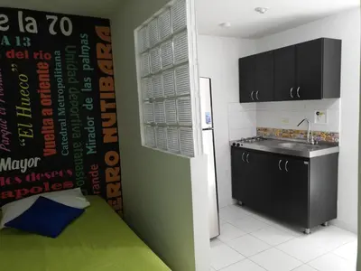 a kitchen with a bed and a sink and a refrigerator at APARTA ESTUDIO 7051 in Medellín