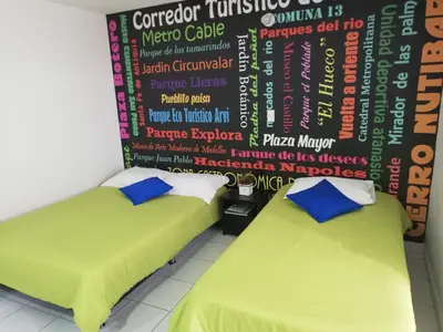 two beds in a room with a wall with words on it at APARTA ESTUDIO 7051 in Medellín