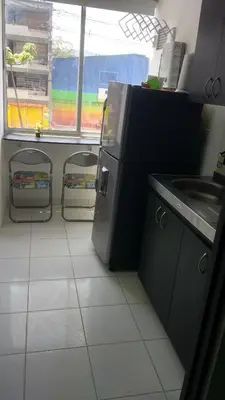 a kitchen with a sink and two stools in it at APARTA ESTUDIO 7051 in Medellín