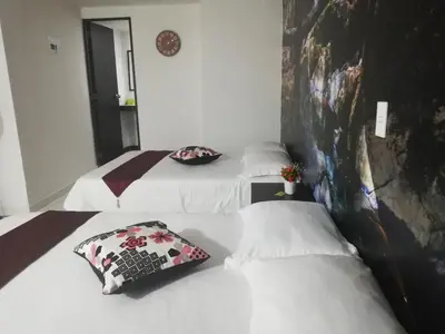 two beds in a hotel room with white sheets at APARTA ESTUDIO 7051 in Medellín