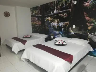 two beds in a room with a painting on the wall at APARTA ESTUDIO 7051 in Medellín
