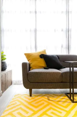 a living room with a couch and a yellow rug at Factory Lofts Hotel in Medellín