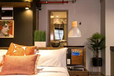 a bedroom with a bed with pillows and a mirror at Factory Lofts Hotel in Medellín