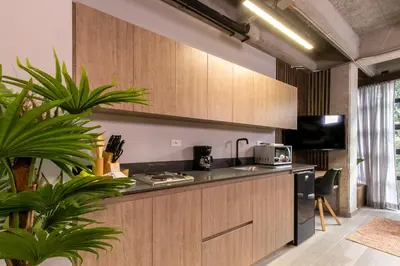 a kitchen with wooden cabinets and a counter top at Factory Lofts Hotel in Medellín