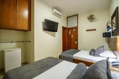 a hotel room with two beds and a tv at Hotel Sauces del Estadio in Medellín