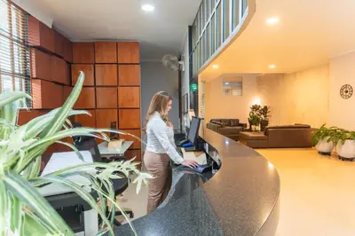 a woman standing at a desk in an office at Hotel Sauces del Estadio in Medellín