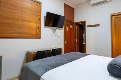 a hotel room with a bed and a flat screen tv at Hotel Sauces del Estadio in Medellín