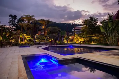 a swimming pool with blue lights in a backyard at Termales El Otoño in Manizales
