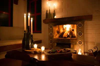 a fireplace with candles and a table with food in front of it at Termales El Otoño in Manizales