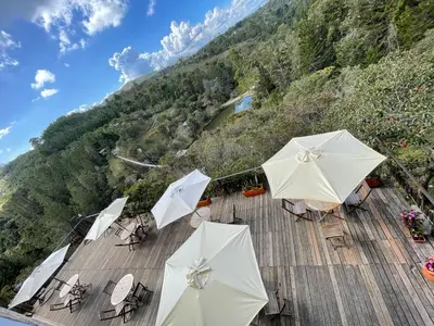 a group of white umbrellas on a wooden deck at Glamping Ancestros Ecoparque in Girardota
