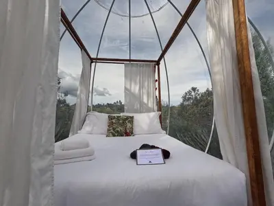 a bed in a canopy tent with a sign on it at Glamping Ancestros Ecoparque in Girardota