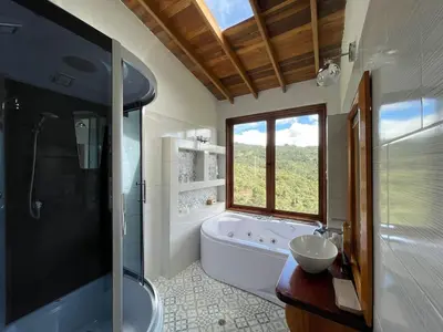 a bathroom with a tub and a toilet and a sink at Glamping Ancestros Ecoparque in Girardota