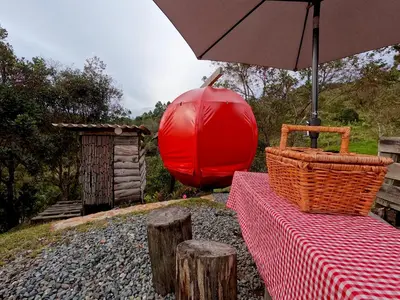 a picnic table with an umbrella and a red balloon at Glamping Ancestros Ecoparque in Girardota