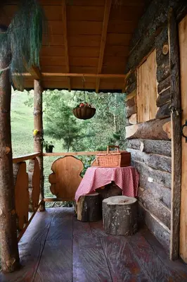 a porch of a log cabin with a table in it at Glamping Ancestros Ecoparque in Girardota