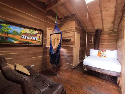 a room with a bed and a hammock in a cabin at Glamping Ancestros Ecoparque in Girardota