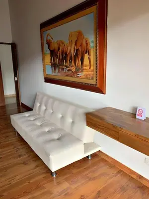 a white bench in a room with a painting on the wall at Glamping Ancestros Ecoparque in Girardota