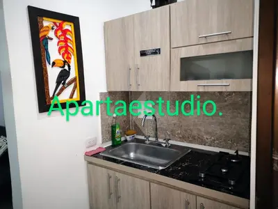 a kitchen with a sink and a sign on the wall at Cómodos y acogedores Apartaestudios - Manizales in Manizales