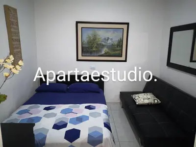 a bedroom with a bed and a couch at Cómodos y acogedores Apartaestudios - Manizales in Manizales