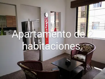 a living room with chairs and a clock on the wall at Cómodos y acogedores Apartaestudios - Manizales in Manizales
