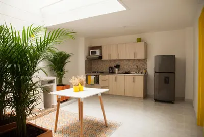 a kitchen with a white table and a refrigerator at Home Aris Apartments 201 in Medellín
